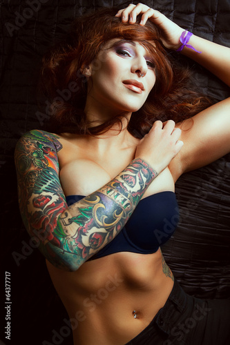 Beautiful girl with stylish make-up and tattooed arms: