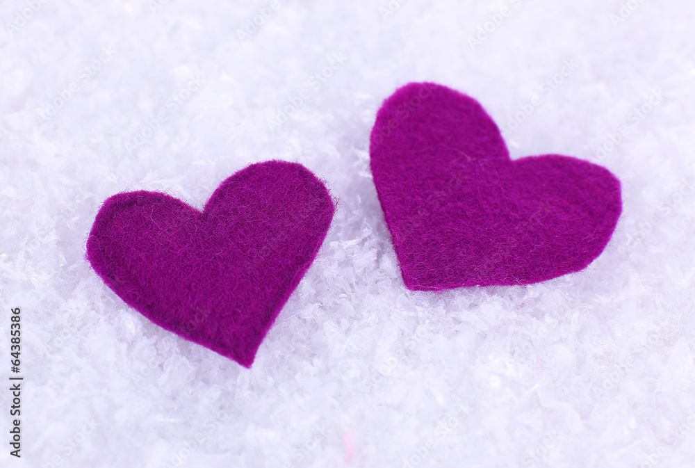 Obraz premium Little felt hearts on snowy background