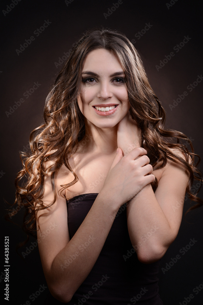Beautiful young woman with long hair on dark brown background Beautiful young woman with long hair on dark brown background