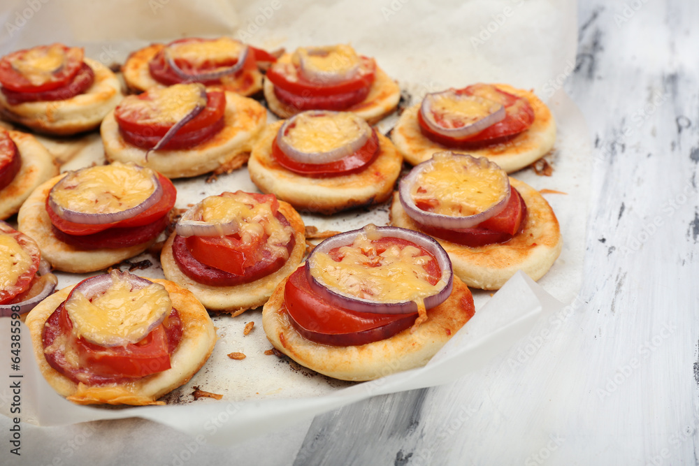 Small pizzas on baking paper close up Small pizzas on baking paper close up
