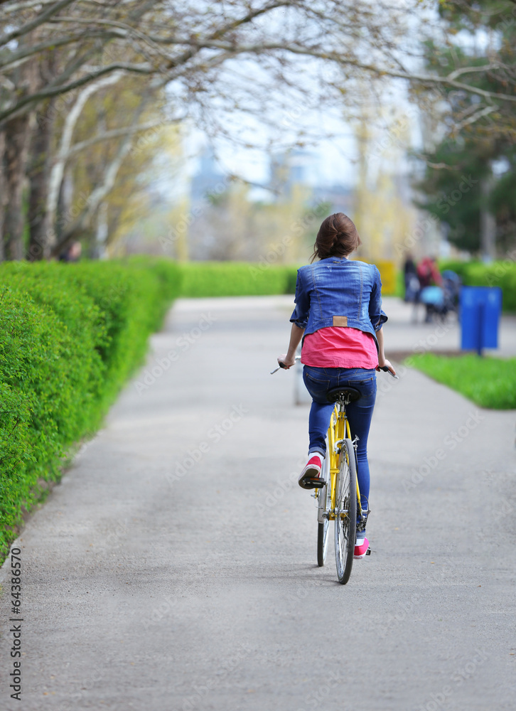 Young woman riding on bicycle in park