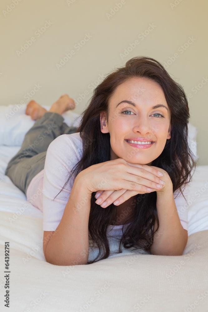 Confident woman smiling while in bed