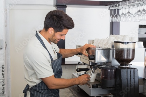 Waiter making cup of coffee at coffee shop