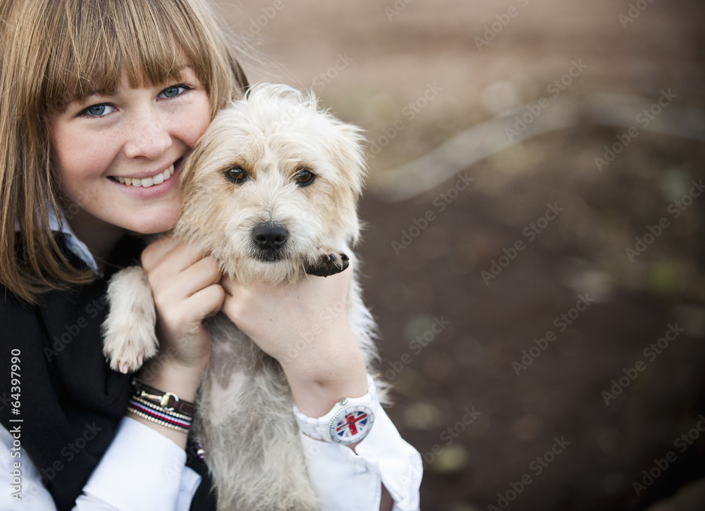 A woman hugging a small hairy terrier puppy. A woman hugging a small hairy terrier puppy.
