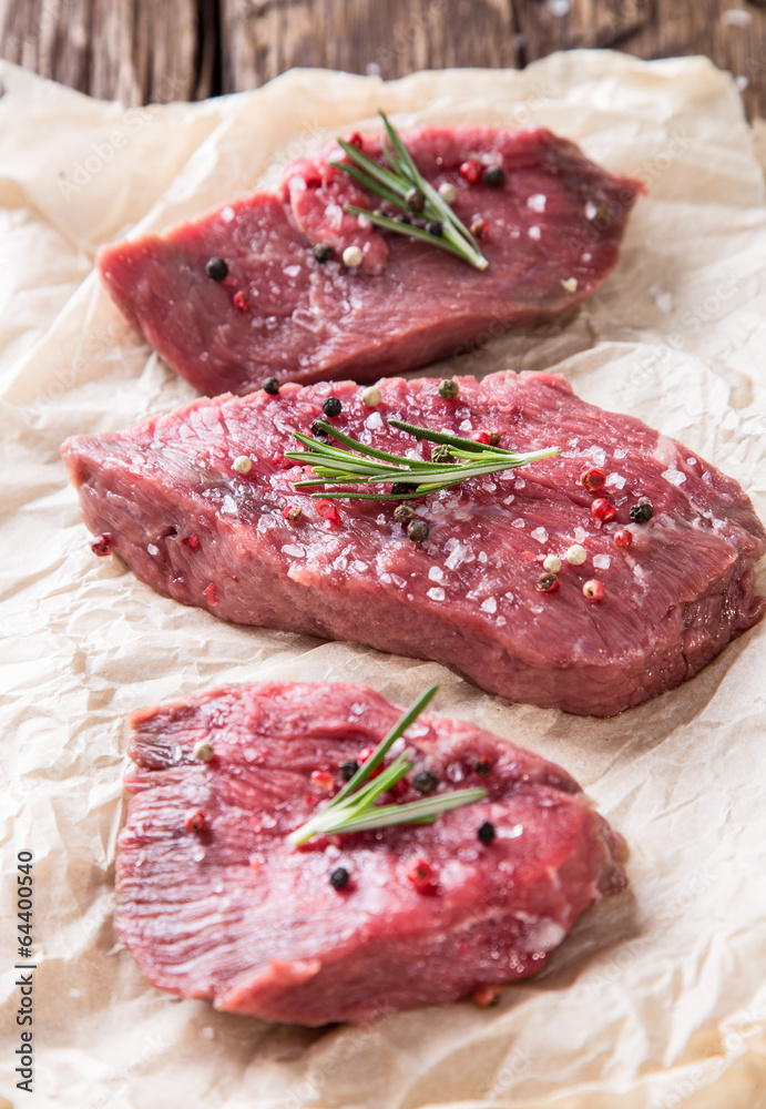 Raw beef steak on wooden table Raw beef steak on wooden table