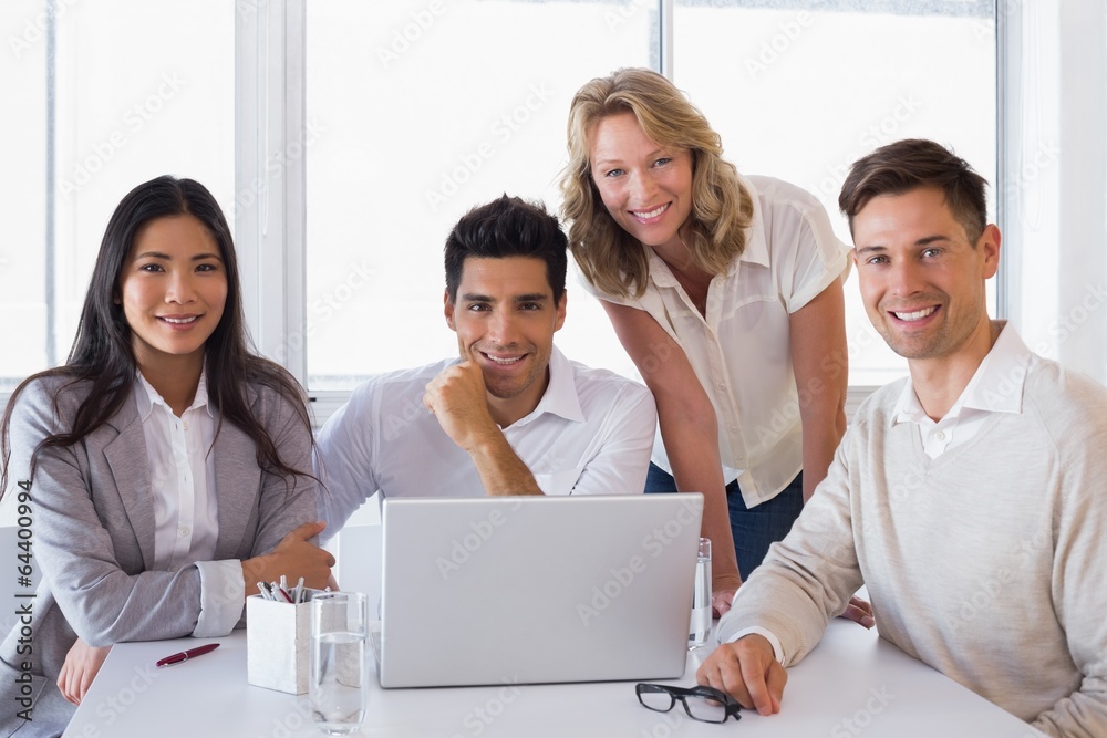 Casual smiling business team having a meeting using laptop Casual smiling business team having a meeting using laptop