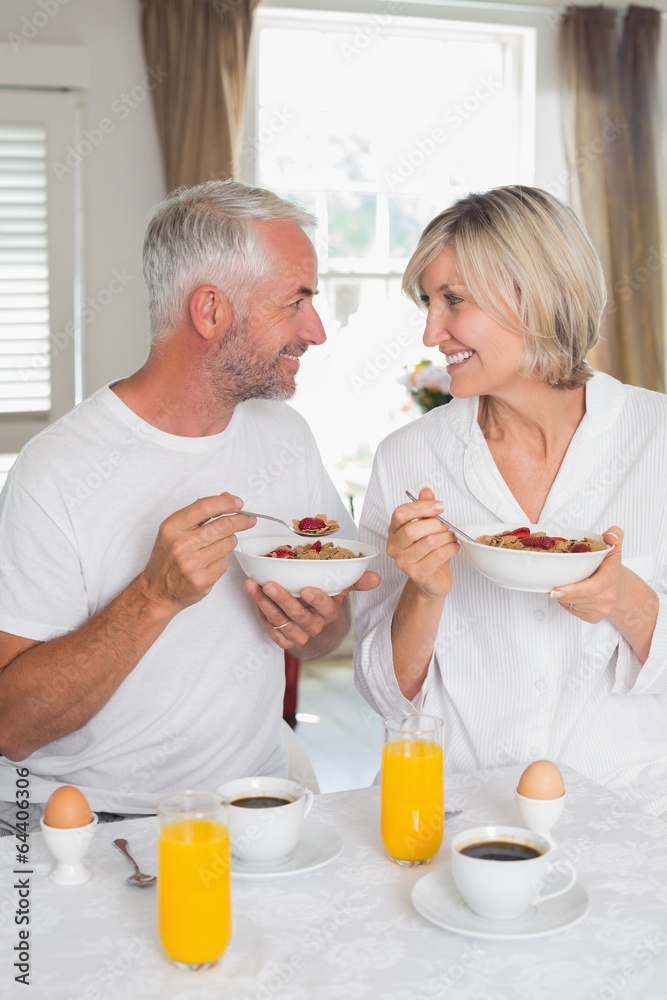 Couple looking at each other and having breakfast Couple looking at each other and having breakfast