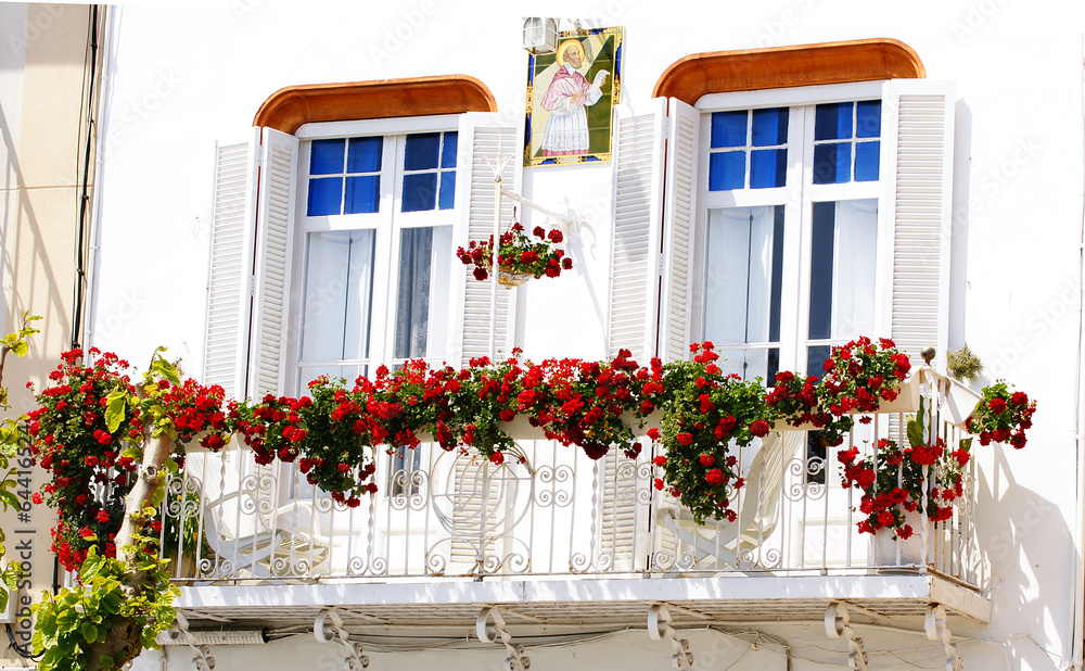 Balcón con flores en una fachada de Sitges, Barcelona