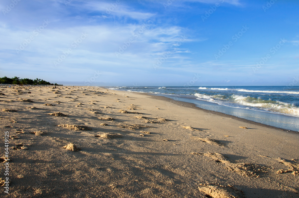 ocean and sandy beach on blue sky background