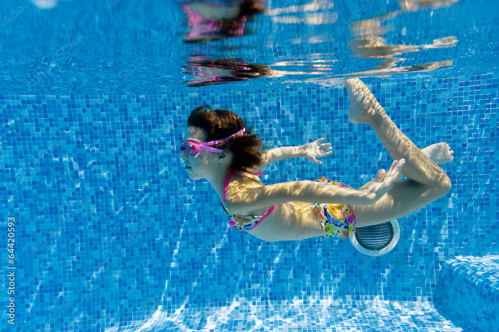 Happy active underwater child swims in pool and having fun