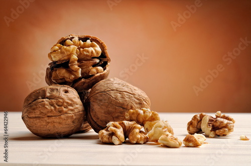 group of walnuts on a table with brown background