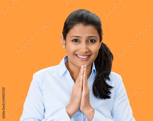 Namaste. Smiling young woman on orange background  photo