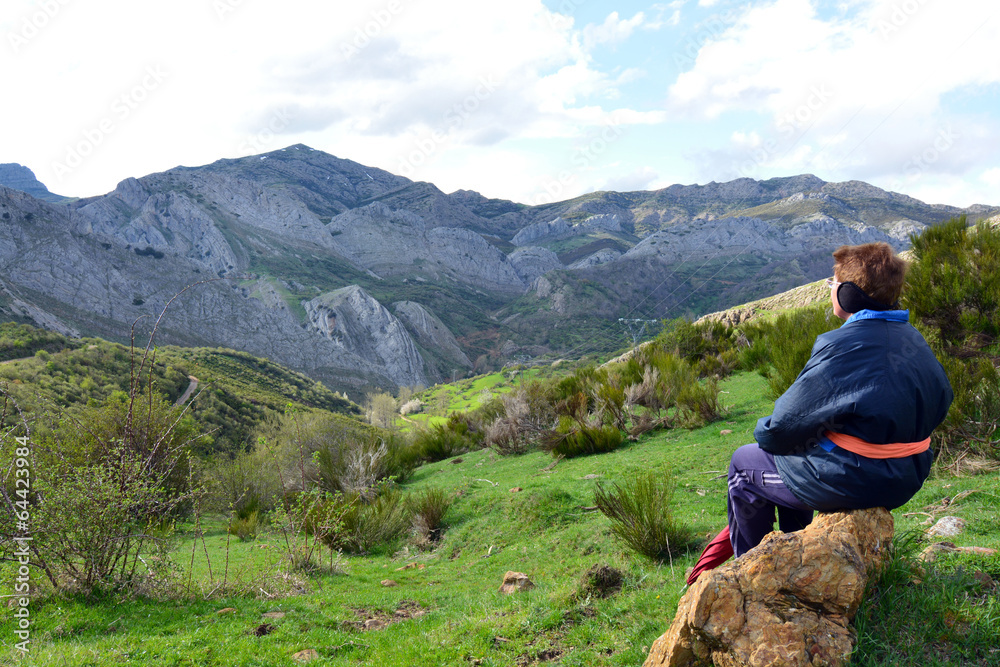 mujer mayor sentada disfrutando del paisaje de montaña
