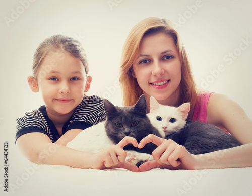 two girls hugging cats