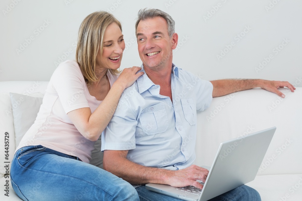Relaxed couple using laptop at home Relaxed couple using laptop at home