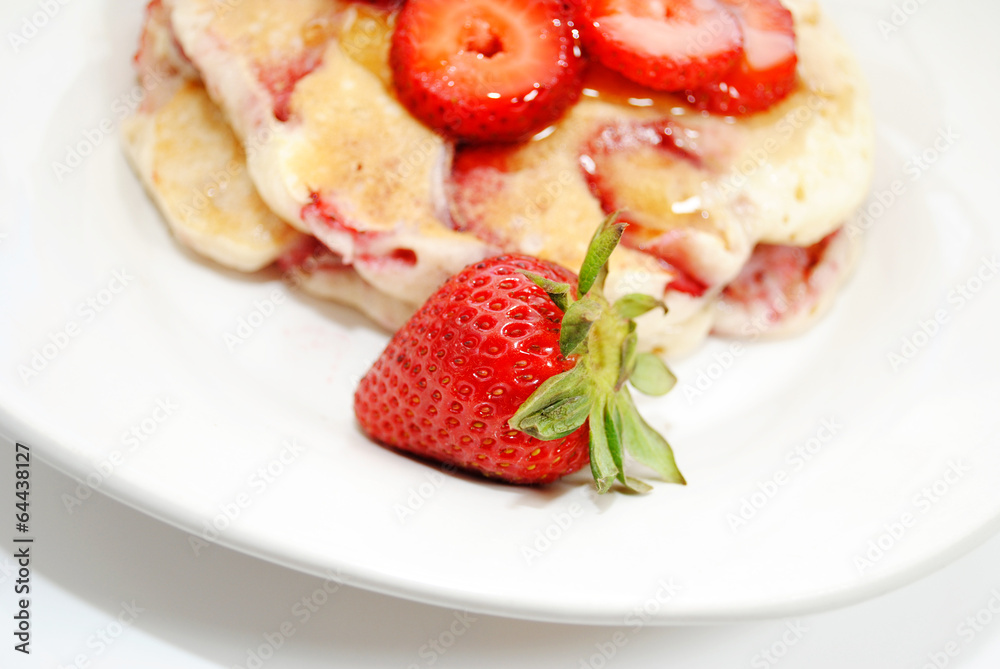 Close-Up of a Whole Strawberry in Front of Hotcakes Close-Up of a Whole Strawberry in Front of Hotcakes