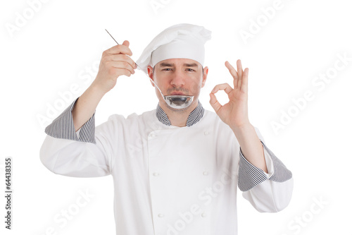 Fotografie Young chef tasting food from ladle