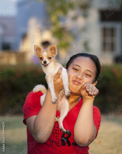 girl and pomeranian dog playing in park photo