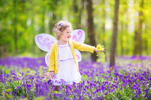 Adoable toddler girl in fairy costume in bluebell forest photo