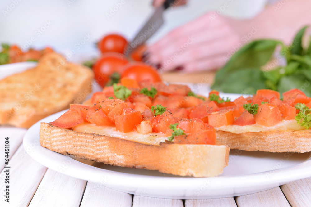 Delicious bruschetta with tomatoes on plate on table close-up Delicious bruschetta with tomatoes on plate on table close-up