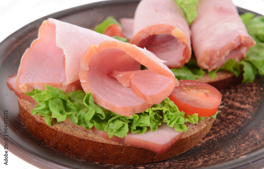 Delicious sandwiches with lettuce and ham on plate close-up