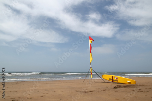 Lifeguards yellow surf with flags on an english beach