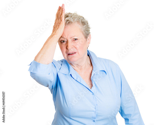 Duh moment. Old woman with hand on head, realization of mistake photo