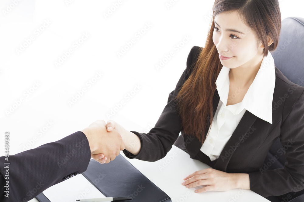 smiling business woman shaking hands with client in her office smiling business woman shaking hands with client in her office