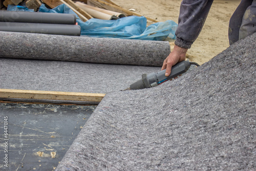 Worker cutting insulation material for basement wall 3