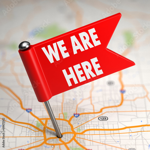 We Are Here - Small Flag on a Map Background.