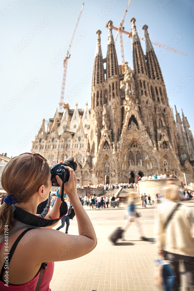 Fototapeta premium Young woman taking picture of Sagrada Familia.
