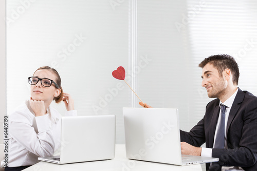 Work romance between two business people holding a heart