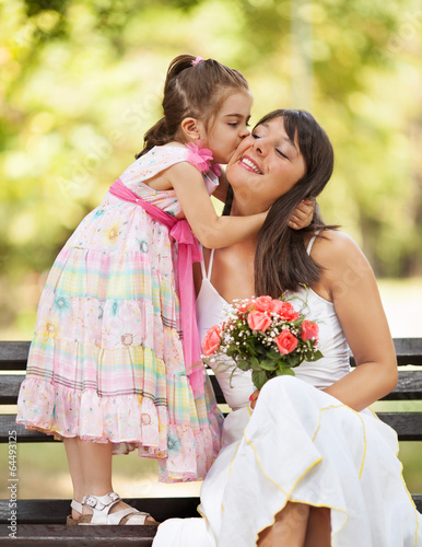 Mother and little daughter embracing outdoors.