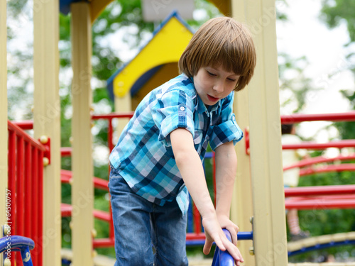 kid playing on playground in summer outdoor park