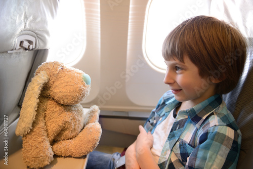 little boy inside airplane during flight playing with his favori photo