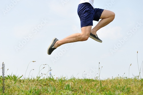 草原の上をジャンプする男性