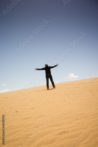 jubelnder Mann auf einsamer Sanddüne