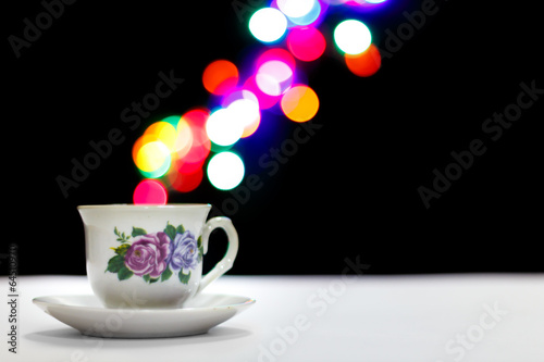Porcelain tea cup with colorful bokeh-style vapor