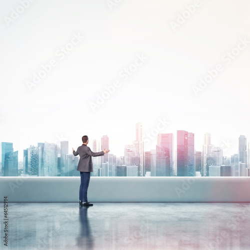 business man standing on a roof and looking at city