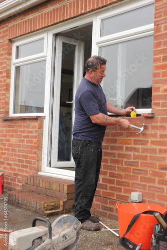 A Window fitter removing old windows in preparation for new ones