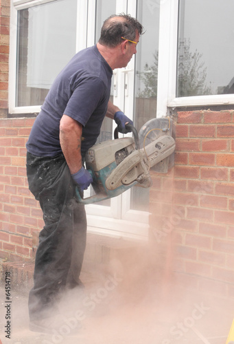 A window fitter using a disc cutter on brickwork
