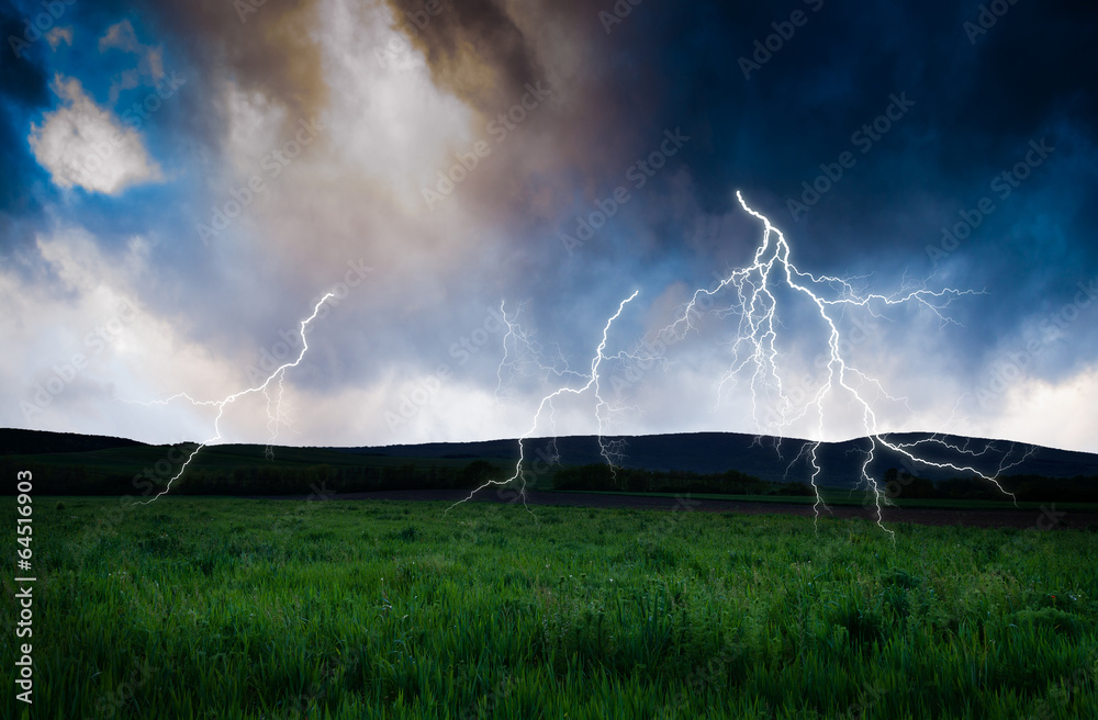 Obraz premium Thunderstorm with lightning in green meadow