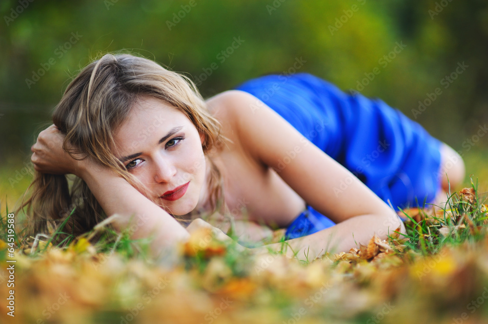 girl in a blue dress on yellow leaves