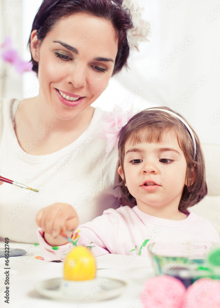 Cute little girl painting Eater eggs with her mommy Cute little girl painting Eater eggs with her mommy