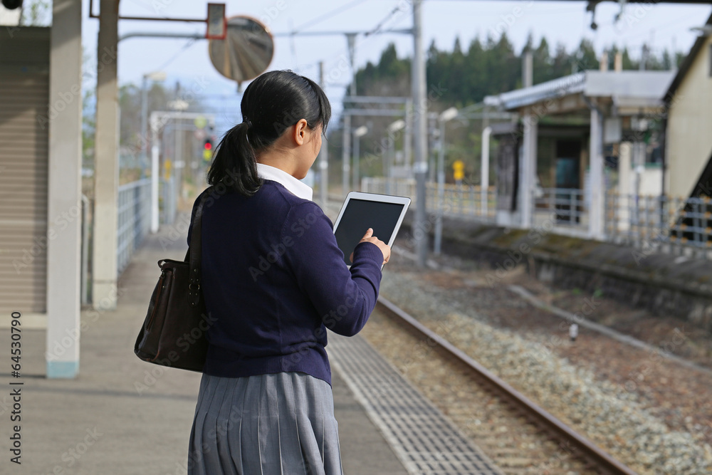 Fototapeta premium 駅のホームでタブレット