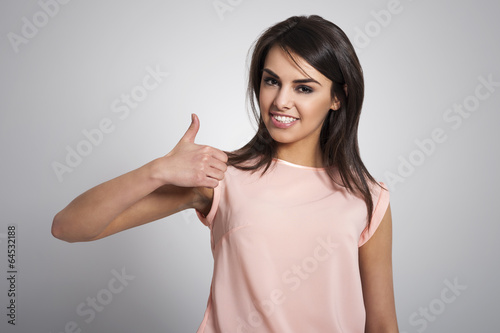 Attractive young woman giving thumbs up