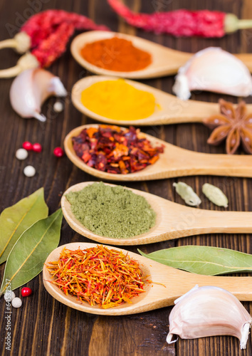 Fototapeta Naklejka Na Ścianę i Meble -  Colorful spices in wooden spoons