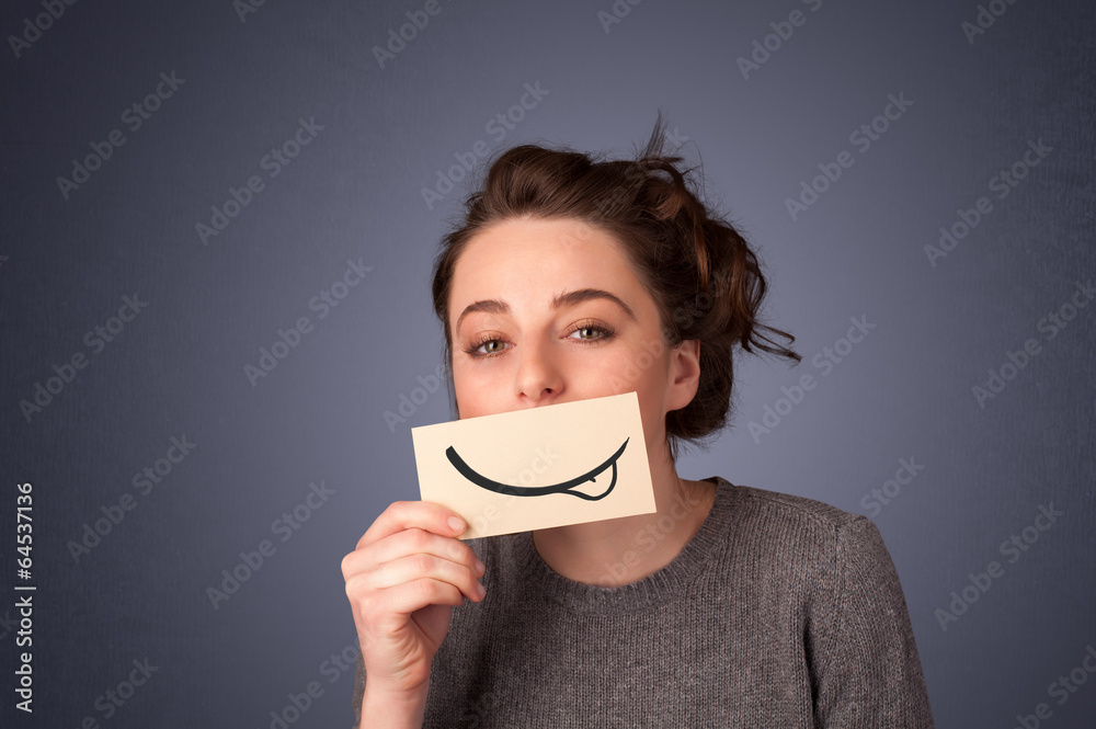 Pretty young girl holding white card with smile drawing Pretty young girl holding white card with smile drawing