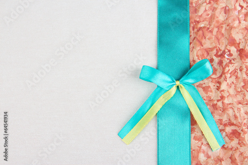 Beige fabric with color ribbon and bow on color paper