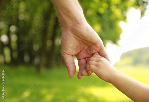 Foto parent holds the hand of a small child